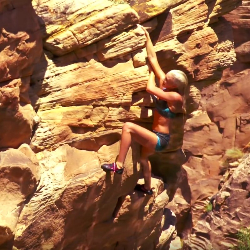 Sierra Blair-Coyle free climbing on riverside cliffs